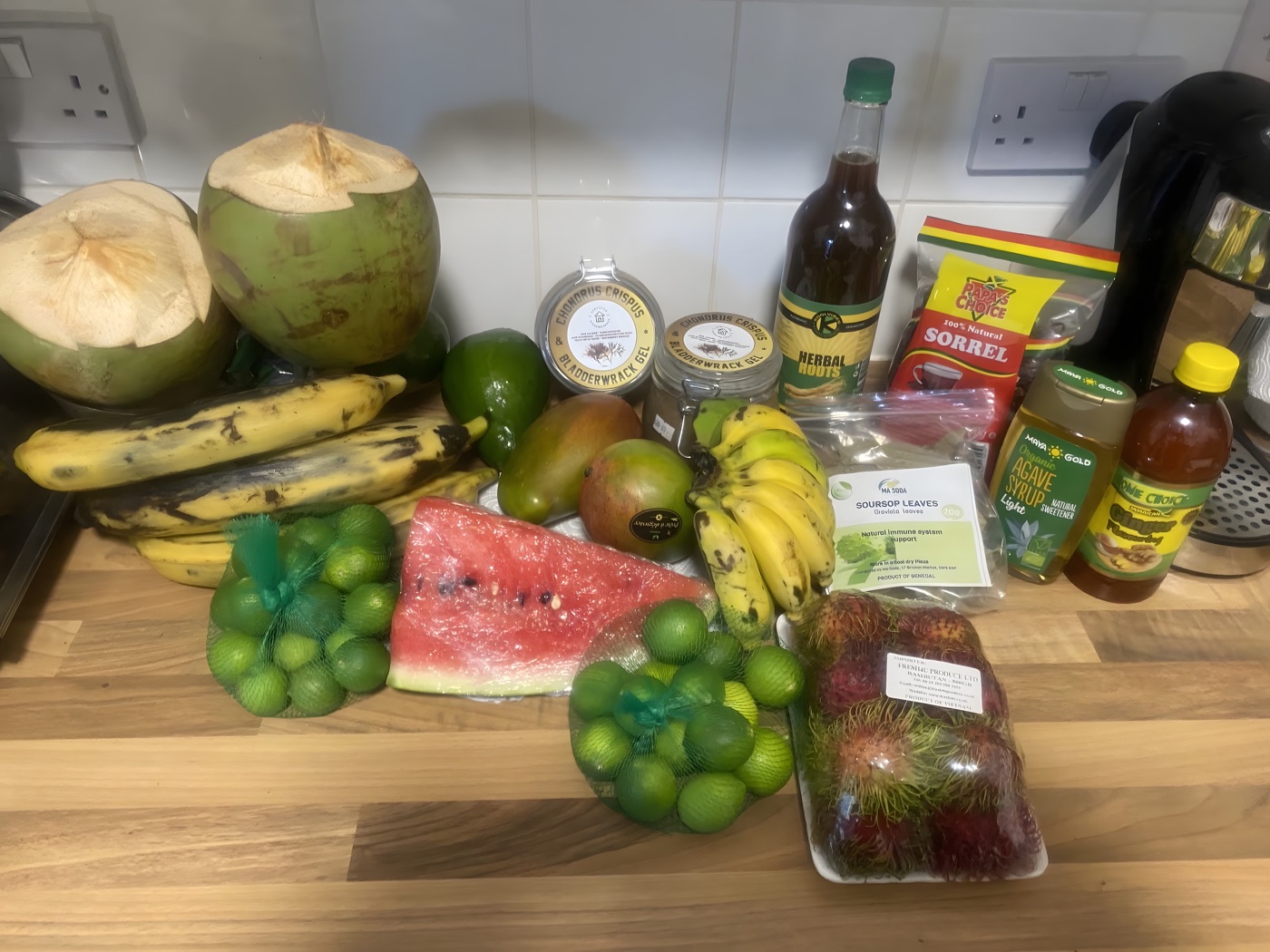 A fresh haul of tropical fruit and herbal roots from Alkaline Roots: coconuts, mango, banana, sorrel and seamoss products