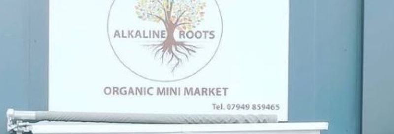 The Alkaline Roots Organic Mini Market shop sign above the storefront on Barking Road