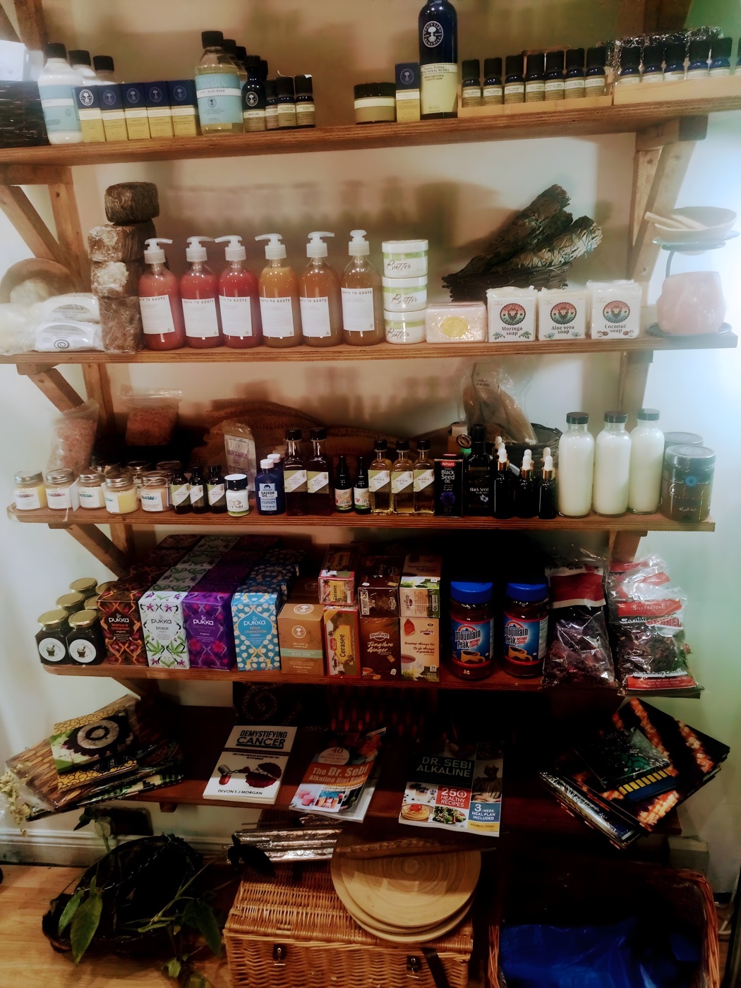 Skin and self-care shelf at Alkaline Roots with natural soaps, oils and alkaline-living books